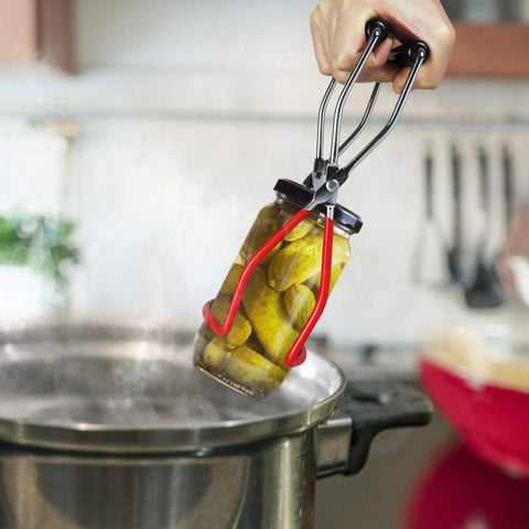 Hand lifting jar from pot using 12 inch stainless steel canning rack with contour handles for pressure canner pot.