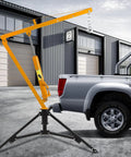 1000 Lb Hydraulic Truck Bed Crane With 360 Degree Swivel Hitch, Three Adjustable Booms, Beefy Pickup Hoist For Lifting Engines, Deer, Or Construction Gear, Yellow next to a parked truck