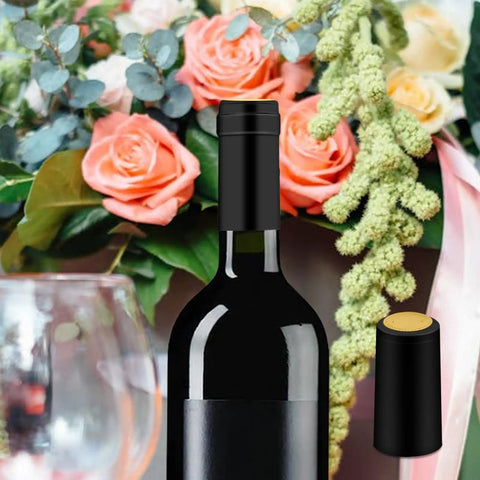 200 Piece Black Heat Shrink Wine Bottle Caps With Tear Tab 30Mm By 60Mm Pvc Shrink Sleeve Seals For Home Cellar No Hassle Application Slick Bottom Line Ready To Roll on a wine bottle with a floral background.