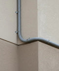 Heavy Duty Flexible Conduit With PVC Coated Galvanized Steel Core Gray Thickened 64mm 10m running along a wall corner.