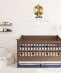 Nordic Ceramic Gold Wall Sconce With On Off Switch above a crib in a nursery with modern decor