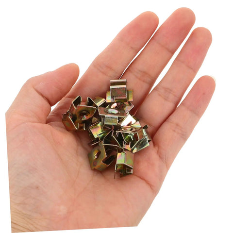 50 Pack Premium Automotive Fastener Clips Golden Iron Captive Nuts held in hand for vehicle shield retention and modifications.