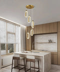 Lit Gold Brushed Modern Pendant Lights For Kitchen Island Three Pack LED Dimmable Mini Pendants For Bedroom Hallway Entryway Home Living Space Lighting Fixture in a modern kitchen setting