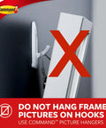 Warning sign showing not to hang framed pictures on hooks with Command logo in background.