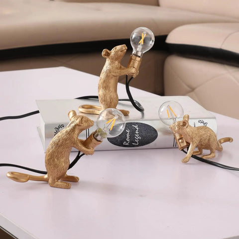 Three Style Resin Mouse Desk Lamp With LED Glow Featuring Running Sitting And Standing Cute Mouse Figures In Gold Finish For Bedroom Or Study Room Decor Plug In Table Light With Easy On Off Switch, on a book and table surface