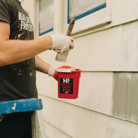 Person using Grab And Go 32 Ounce Paint Pail With Magnetic Brush Holder And Built In Scraper for trim cut-ins on house siding