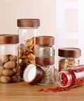 Slick High Borosilicate Glass Storage Jars With Acacia Wood Lids Gonna Keep Your Kitchen Fresh These Dope Food Canisters For Coffee Sugar Nuts Are Straight Up A Nifty Counter Top Setup with various snacks.