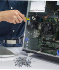 Person repairing computer with screwdriver, pile of screws in foreground, open computer case with visible components.