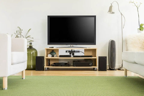 Modern living room setup with TV and speakers, showcasing Eight Outlet Pivot Plug Power Strip With Six Foot Cord And Phone Line Protection.