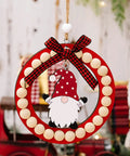Festive wreath with wooden beads, red bow, and gnome decoration hanging on a rope.