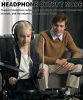 Child playing Beginner Electric Drum Set With Quiet Mesh Pads 150 Built In Sounds using headphone output, adult observing
