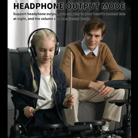 Child playing Beginner Electric Drum Set With Quiet Mesh Pads 150 Built In Sounds using headphone output, adult observing