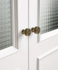 Premium Top Shelf Solid Brass Cabinet Knobs 1.1 Inch Knurled Hardware Antique Brushed Finish on white cabinet doors.
