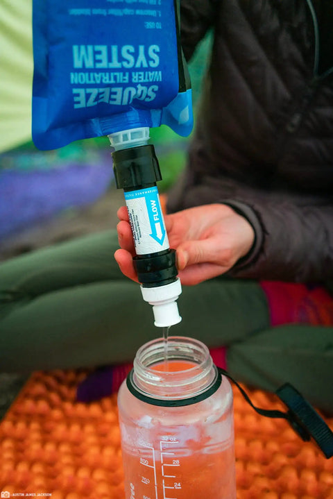 Person using Compact Palm-Sized Water Filtration System With Dual Threaded Mini Plus And Faucet Adapter for clean water