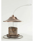 Real Deal Backyard Wild Bird Food Mix Featuring Natural Cherry Flavor And Hearty Sunflower in a glass tube feeder with copper lid.