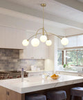 Gold 5-Light Sputnik Ceiling Chandelier With Glass Globe Shades For Dining Room Kitchen And Bedroom, installed in a modern kitchen.