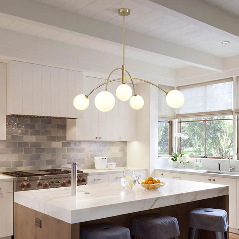 Gold 5-Light Sputnik Ceiling Chandelier With Glass Globe Shades For Dining Room Kitchen And Bedroom, installed in a modern kitchen.