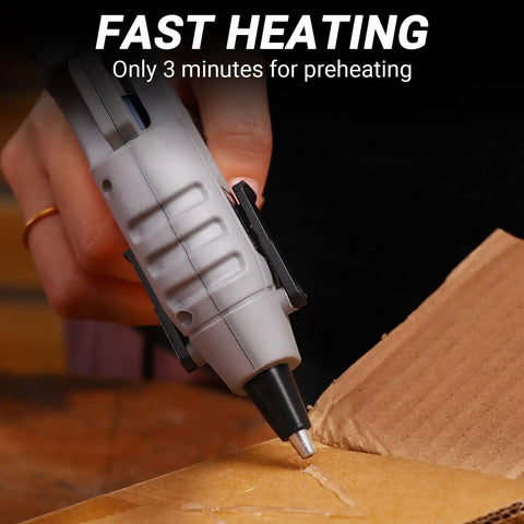 Person using 20W High Temp Mini Glue Gun Kit With 55 Inch Cord Anti Drip Nozzle Includes 30 Glue Sticks For Crafting DIY Projects School Art Quick Home Repairs Portable Gray Hot Glue Gun on cardboard, fast heating feature highlighted.