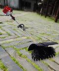 52CC Gas Walk Behind Sweeper Powered By A Muscle 2.3HP Two Stroke Engine on a cobblestone path, ready to clear debris.
