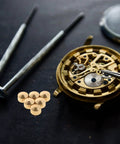 20 Piece Clock Nut Set For Repair And DIY Projects with metal movement nuts, gaskets, and watch movement parts on black surface