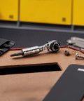 Ultra Compact One Quarter Inch Ratchet Wrench For Tight Spaces Stainless Steel EDC Tool on table with screws and bits