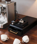 Electric Portafilter Cleaner With Espresso Knock Box And Grounds Tray, compact design with integrated brush on wooden countertop.