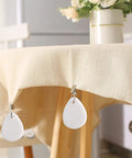 12 Piece Teardrop Marble Tablecloth Weights With Metal Clips White For Indoor Outdoor Use, clipped on cream tablecloth edge