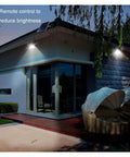 Top Shelf Solar Floodlights Featuring No Sweat Dusk To Dawn Sensor And Weatherproof Remote Control for garden lighting on a house exterior.
