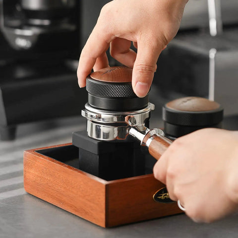 Hand uses 58mm Coffee Distributor And Espresso Leveler With Adjustable Height Stainless Steel Wedge Base for precise dosing in portafilter.