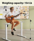 Man playing guitar on Gamork Electric Standing Desk Frame For 40 To 63 Inch Tabletops, Heavy Duty Up To 154 Lbs.