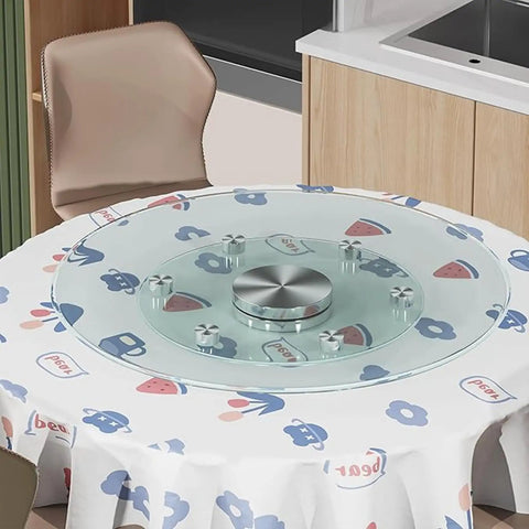 Game Changer Lazy Susan Serving Tray With Whisper Smooth Tempered Glass Top and Beefed Up Aluminum Bearing Base For No Sweat Dining Table Sharing and Hassle Free Entertaining Size Thirty Five Inches Wide on a patterned table.