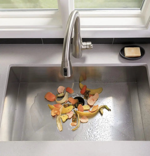 Half Horsepower Batch Feed Garbage Disposer For Home Kitchen with food scraps in stainless steel sink