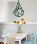 Wood Beaded Chandelier Light Fixture For Boho Farmhouse Vibe Pendant Ceiling Lamp in rustic grey-blue over a dining table.