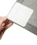 Hand holding Rug Stays Put Non Slip Gripper Pads, 4 Pack For Hardwood Floors, showing ultra thin and nearly invisible design