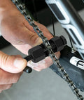 Using the Universal Bike Chain Breaker Tool For 1 To 13 Speed Chains With Spare Replaceable Pin on a bike chain
