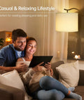 Couple using tablet near Dope Modern LED Arched Floor Lamp With Natural Linen Shade, cozy living room atmosphere.