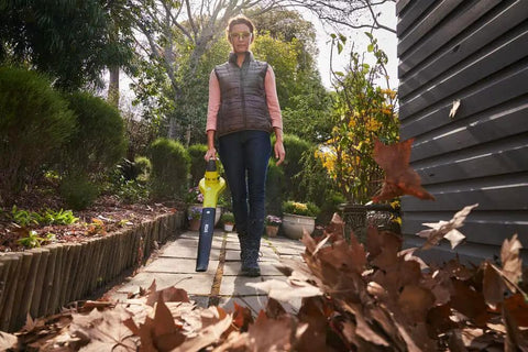 Person standing outdoors with No Sweat Heavy Duty 18V Cordless Yard Leaf Blower with comfy grip for leaf cleanup