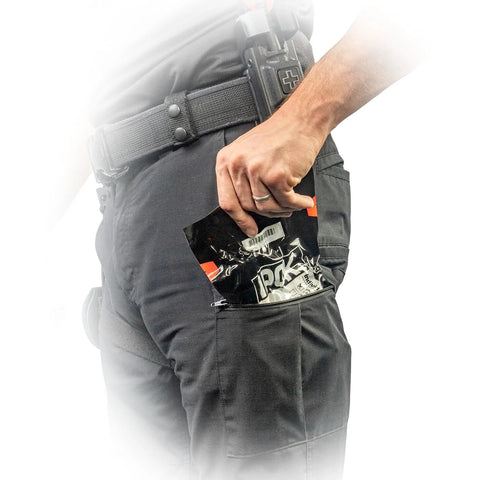 North American Rescue IPOK compact first aid kit in tactical pants pocket; gauze packets visible.