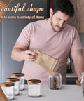 24 Pack Glass Canister Set With Tight Wood Lids For A No Sweat Pantry Setup, 17 Oz Food Jars being filled with coffee beans.