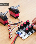 Six Channel Servo Tester And Motor Controller For RC Cars Planes And Robots With two servo motors being tested on table