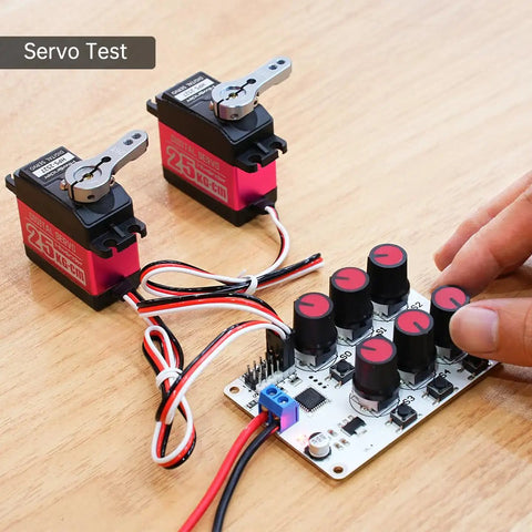 Six Channel Servo Tester And Motor Controller For RC Cars Planes And Robots With two servo motors being tested on table