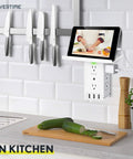 8 Outlet Wall Charging Station With 3 USB Ports And Built In Cable Organizer Shelf 4 Pack Plug In No Tools Needed Safety Certified SGS US Tested Space Saving Design For Busy Homes in use in kitchen with tablet.