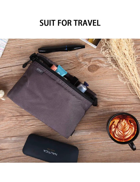 Top view of On The Go Dopp Kit Toiletry Bag for Men Water Repellent Nylon Travel Pouch with pens and coffee nearby