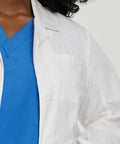 Detail of Relaxed Fit Five Pocket Three Button Full Length White Medical Lab Coat For Women over blue scrubs.