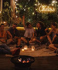 Cheers Neon Sign For Home Bar Wall Decor Battery Or USB Powered Bright Warm White Light Lit For Parties And Bachelorette Celebrations With Home Entertaining Vibe Ultra Lightweight Durable 13 By 5 Inch Sign glowing at a cozy outdoor gathering.