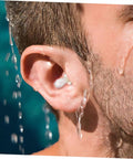 Close-up of reusable silicone ear plug in ear, keeping ear dry while water flows during swimming or showering.