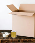 Golden Thermal Label Paper For Shipping And Mailing Self Adhesive Labels With Smooth Surface next to open cardboard box on table
