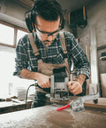 Woodworker using a router with a 10 Piece Quick Toggle Clamps Set For Vertical Downward Push Heavy Duty Hold Downs on a wooden surface