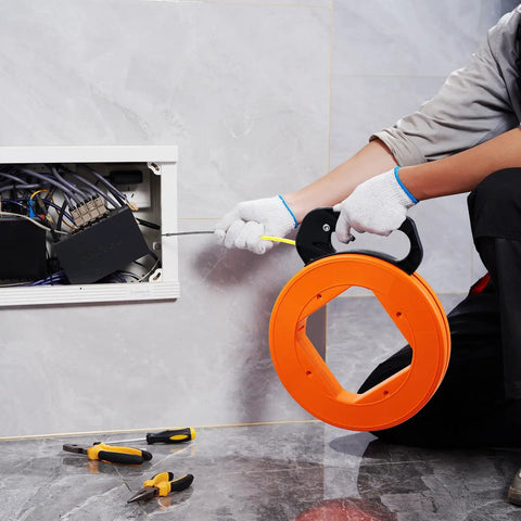 Electrician using 200 Ft Fiberglass Fish Tape For Electrical Wiring Glides Through Tight Cavities Like A Charm With Flexible Non Conductive Line Snake.