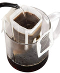 Go To Portable Coffee Filter Bags With Hanging Ear Design in use on a clear glass cup, water pouring in, disposable pour over drip filter